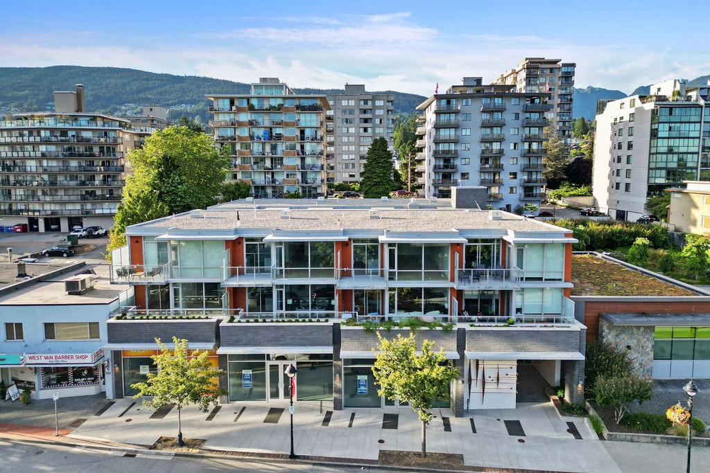1331 Ambleside Residences on Marine Drive, West Vancouver, with street-level retail and North Shore mountains behind
